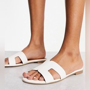 Dune London loopy slip on flat sandals in white.